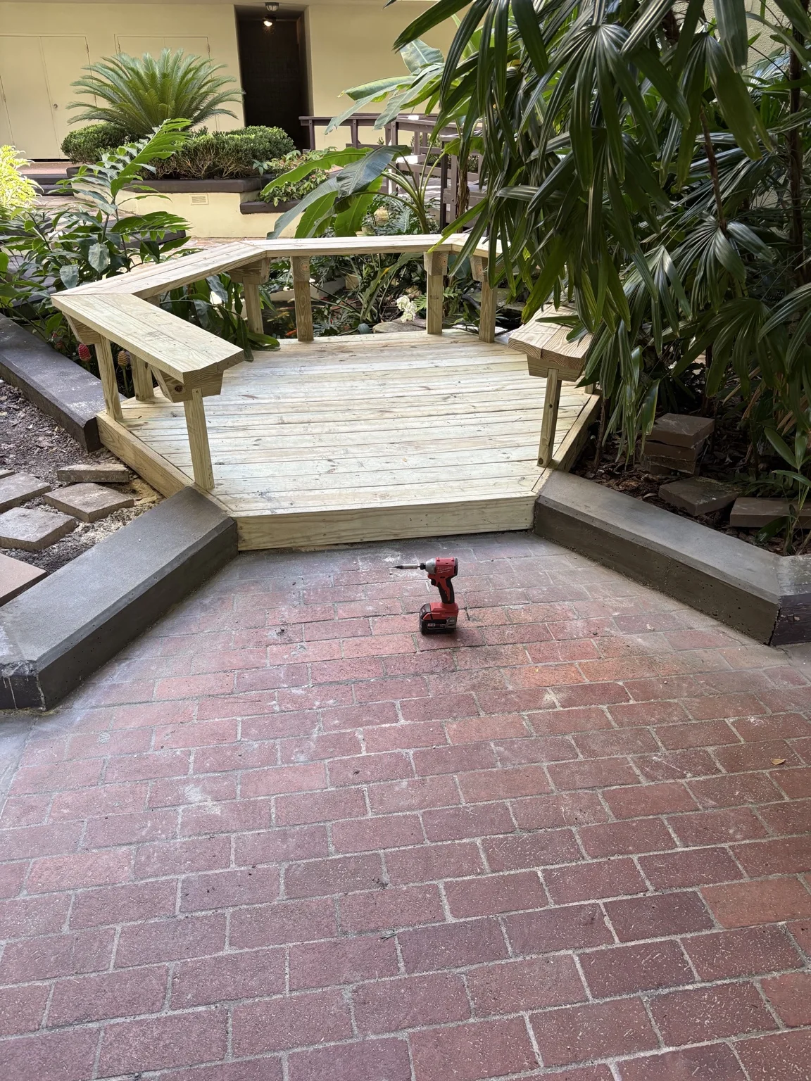 Wood garden bridge with railings over an indoor water feature