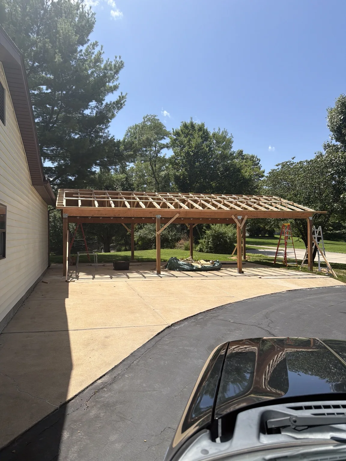 Timber patio cover under construction beside a home